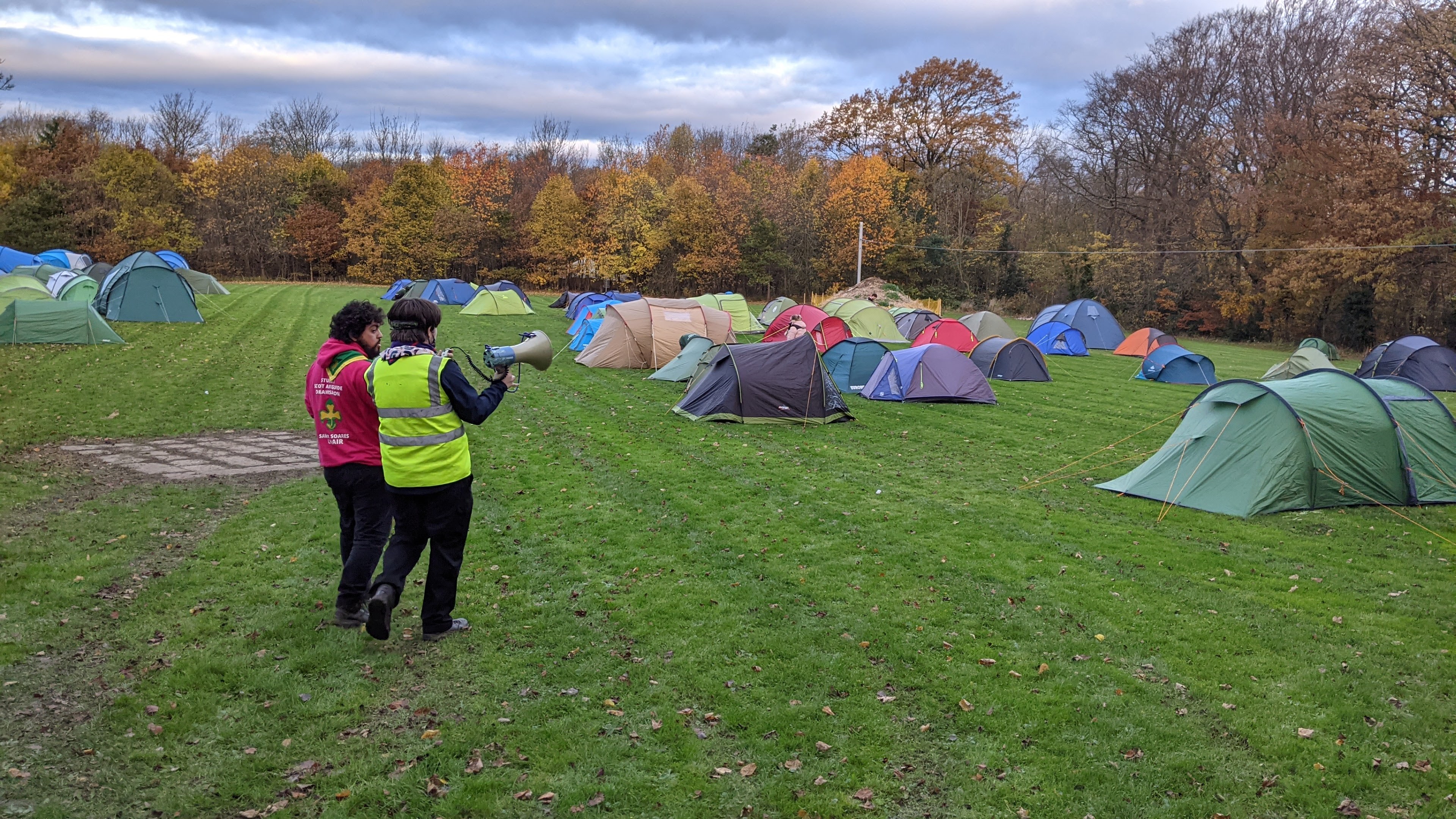 Samir and Jack, with megaphone in hand, overlooking the main camping field at Moor House Adventure Centre, full of tents